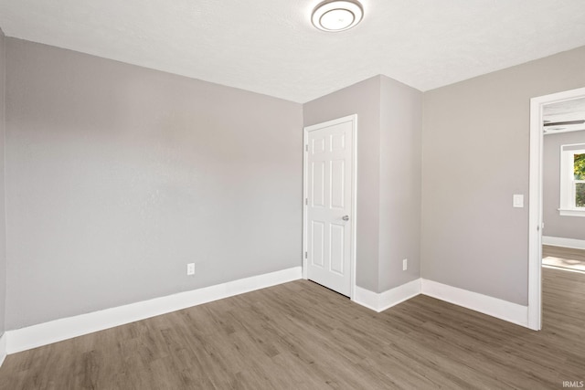 empty room featuring a textured ceiling and dark wood-type flooring