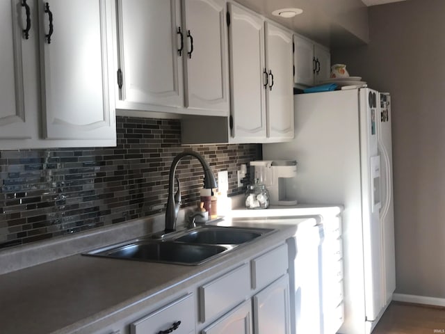 kitchen featuring decorative backsplash, white cabinetry, and sink