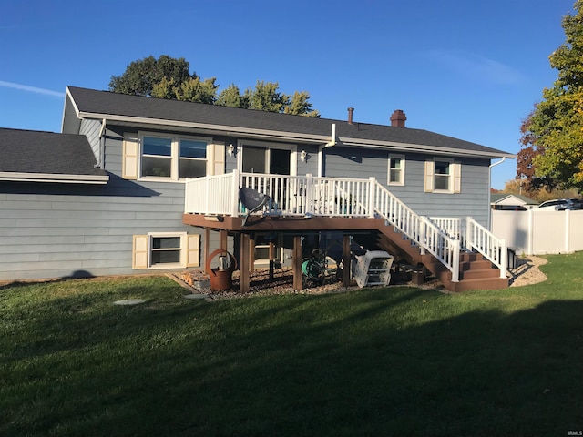 rear view of house with a lawn and a deck