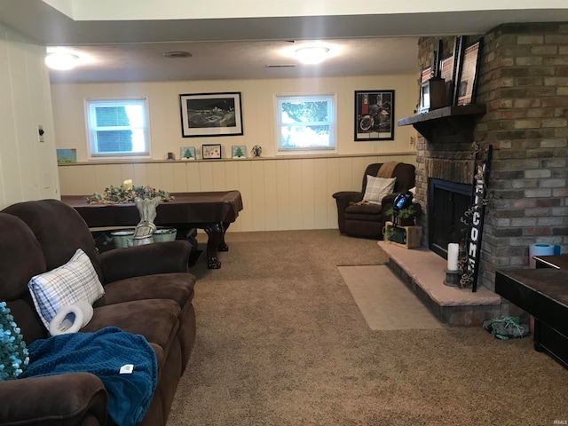 carpeted living room featuring wooden walls, plenty of natural light, billiards, and a brick fireplace