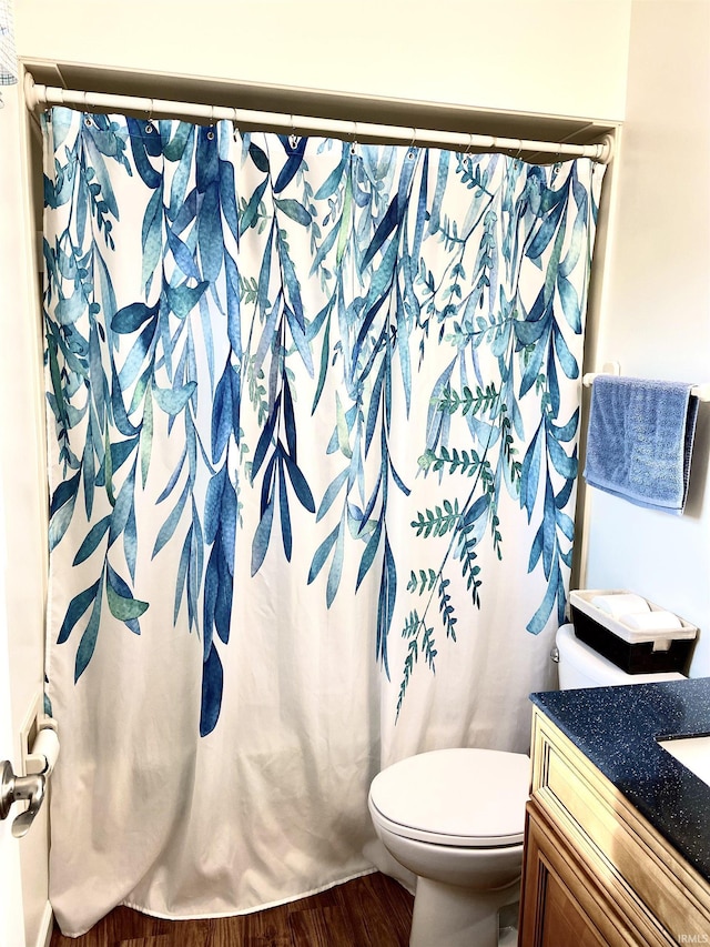 bathroom with a shower with shower curtain, wood-type flooring, vanity, and toilet