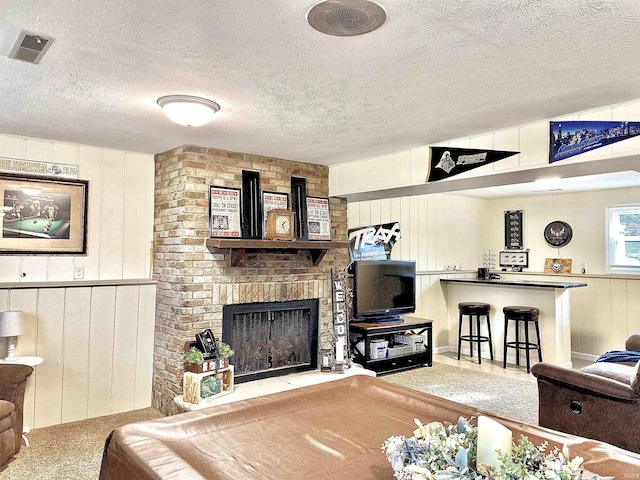 living room featuring a fireplace, a textured ceiling, and billiards