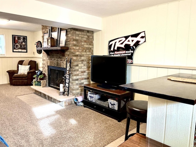 carpeted living room featuring a textured ceiling, a brick fireplace, and wood walls