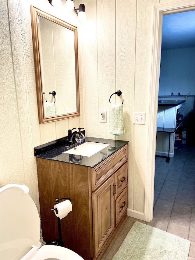 bathroom with tile patterned flooring, vanity, and toilet