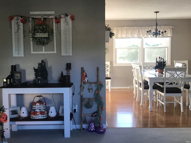 dining room featuring wood-type flooring and an inviting chandelier