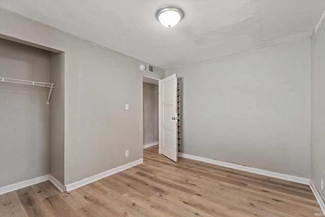 unfurnished bedroom with hardwood / wood-style floors and a closet