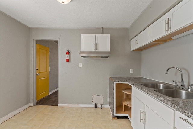 kitchen featuring white cabinetry, a textured ceiling, and sink