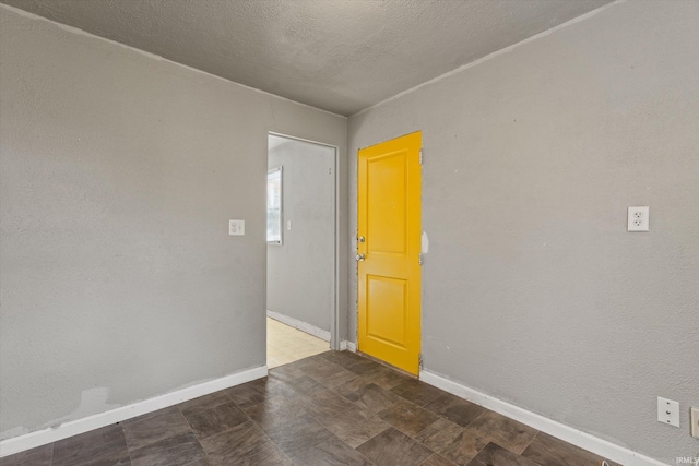 unfurnished room with a textured ceiling