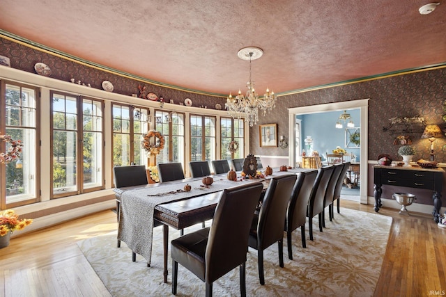 dining area featuring a textured ceiling, wallpapered walls, and a chandelier