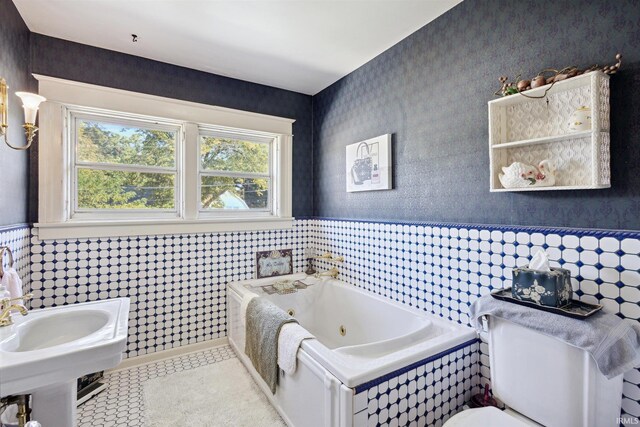 full bathroom featuring a whirlpool tub, tile patterned floors, toilet, a wainscoted wall, and wallpapered walls