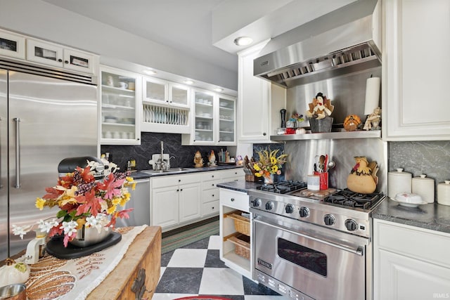 kitchen with high quality appliances, tasteful backsplash, white cabinetry, and wall chimney range hood