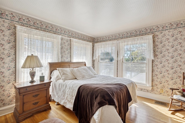 bedroom with light hardwood / wood-style floors and a textured ceiling