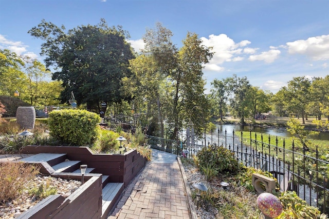 view of community featuring fence and a water view
