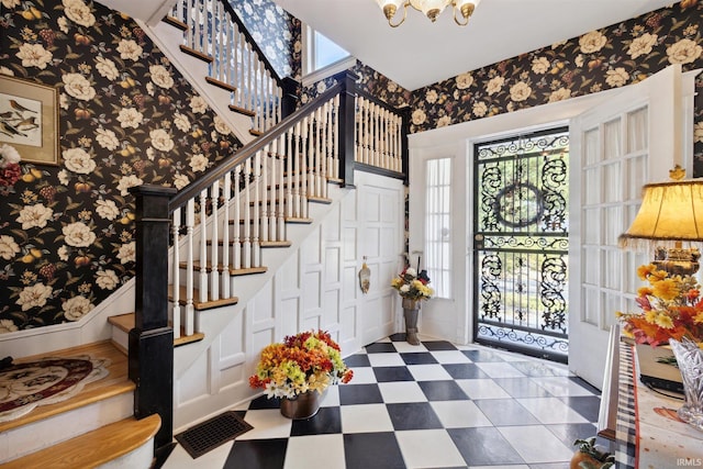 foyer entrance featuring stairway, a wealth of natural light, and wallpapered walls