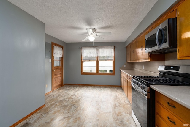 kitchen with appliances with stainless steel finishes, a textured ceiling, and ceiling fan