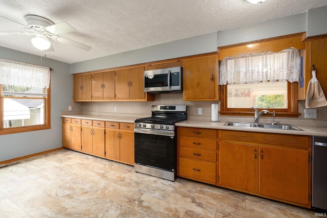 kitchen featuring ceiling fan, appliances with stainless steel finishes, sink, and plenty of natural light