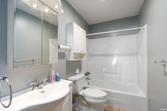 full bathroom with toilet, a textured ceiling, sink, and shower / bathtub combination