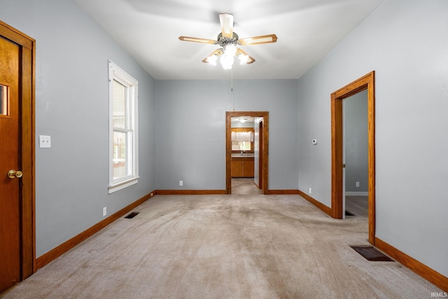 empty room featuring light colored carpet and ceiling fan