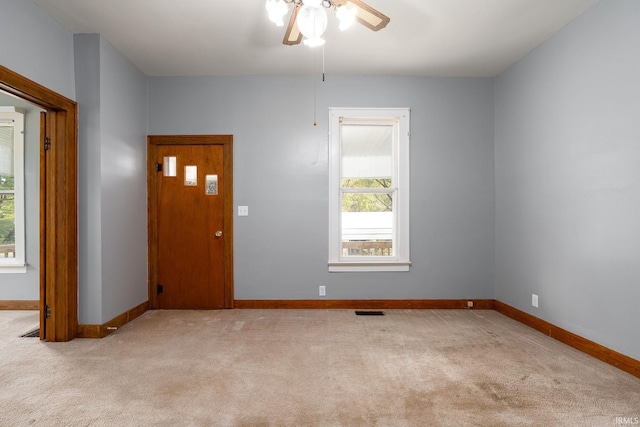 spare room featuring light colored carpet and ceiling fan