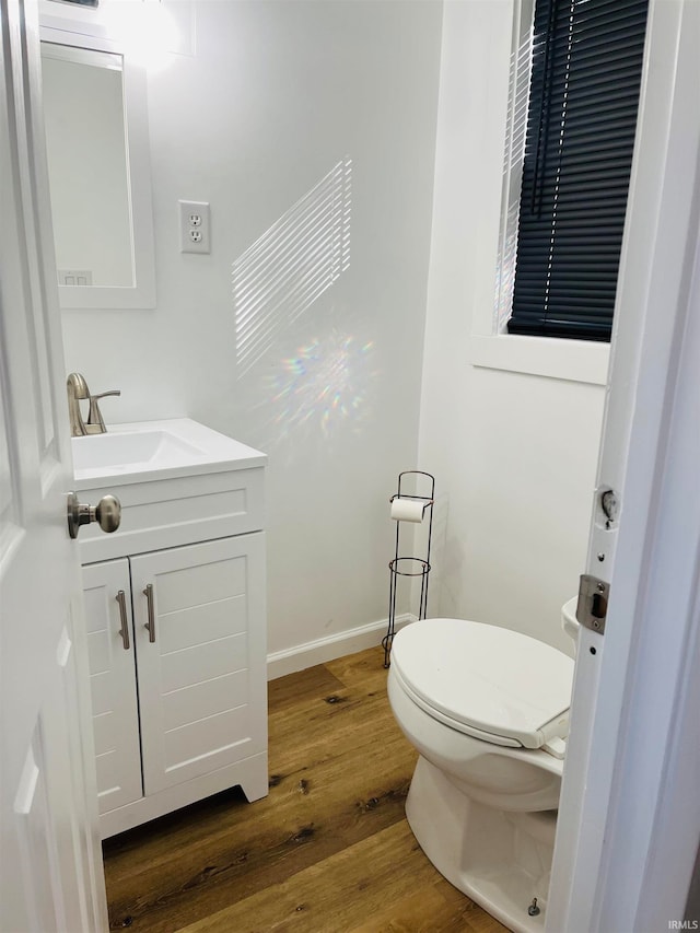 bathroom with vanity, toilet, and wood-type flooring