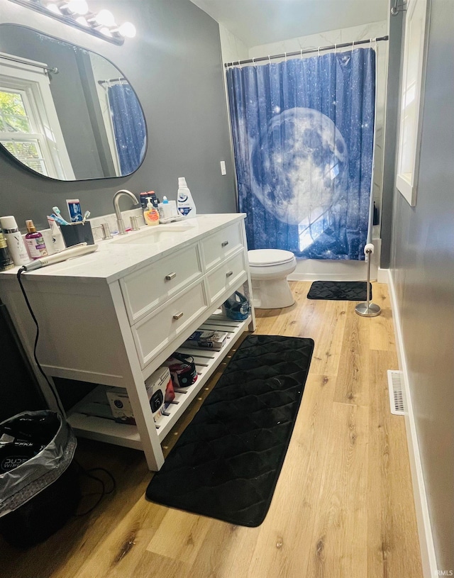 bathroom with vanity, a shower with shower curtain, hardwood / wood-style flooring, and toilet