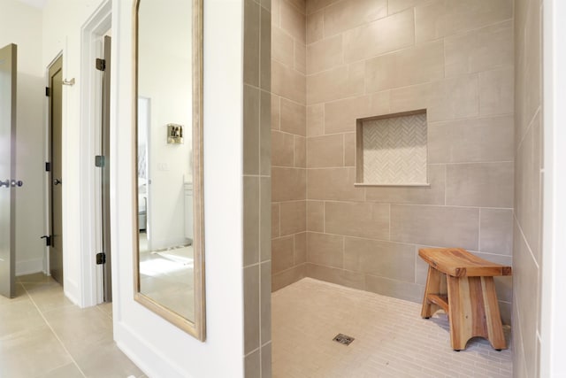 bathroom with tiled shower and tile patterned flooring