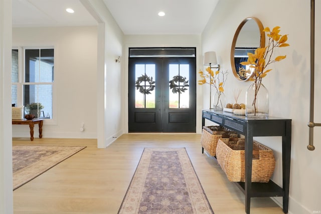 foyer entrance with french doors and light hardwood / wood-style floors