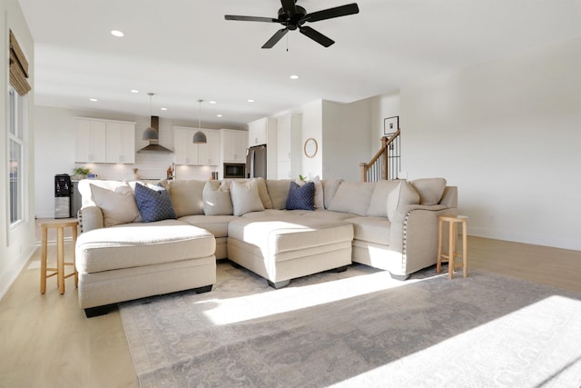 living room with ceiling fan and light wood-type flooring