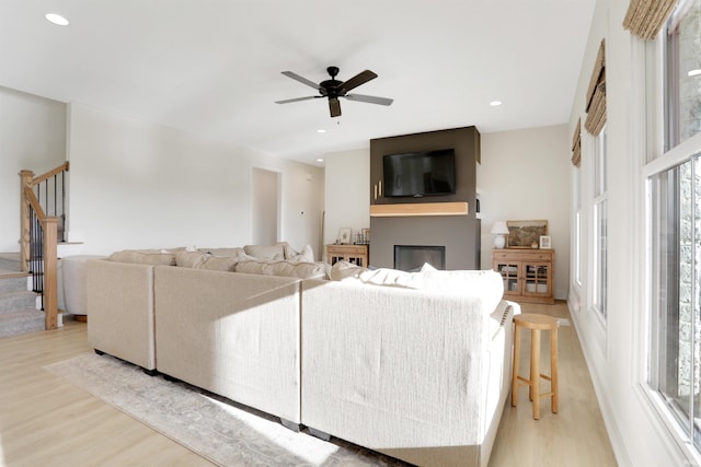 living room with ceiling fan and light wood-type flooring