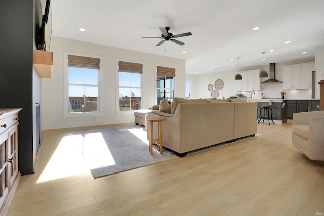 living room featuring light hardwood / wood-style floors and ceiling fan