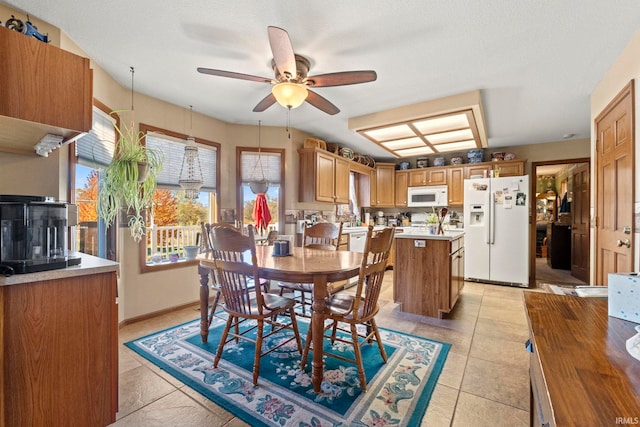 dining area with a textured ceiling, light tile patterned floors, and ceiling fan