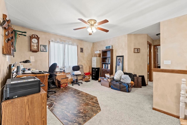 carpeted office space with a textured ceiling and ceiling fan