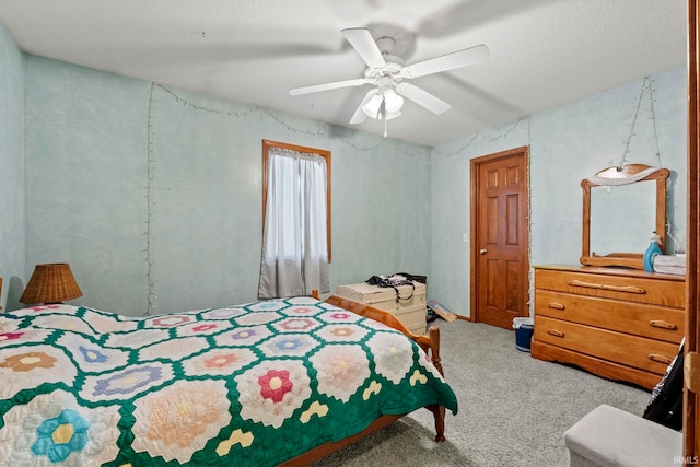 carpeted bedroom with ceiling fan and a textured ceiling