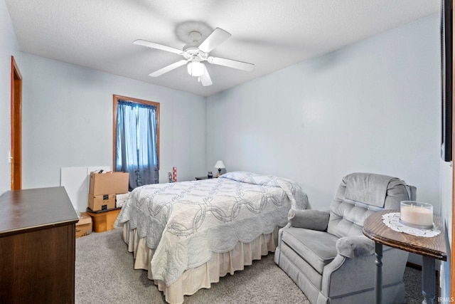 carpeted bedroom with a textured ceiling and ceiling fan