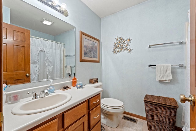 bathroom with vanity, toilet, and tile patterned floors