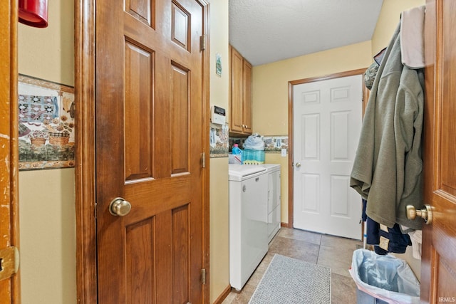 laundry room featuring cabinets, independent washer and dryer, a textured ceiling, and light tile patterned floors