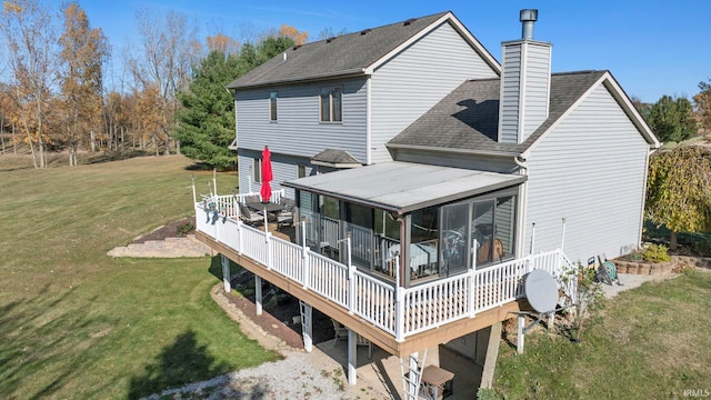 back of property with a wooden deck, a sunroom, and a lawn