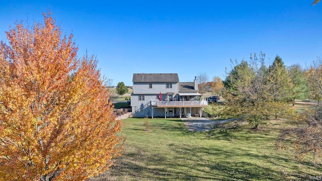 back of property featuring a wooden deck and a lawn