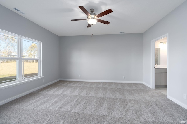 empty room featuring ceiling fan and light carpet