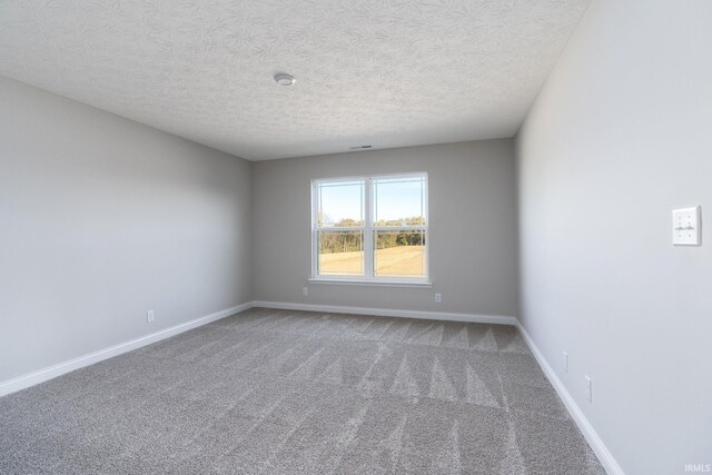 unfurnished room featuring a textured ceiling and carpet floors