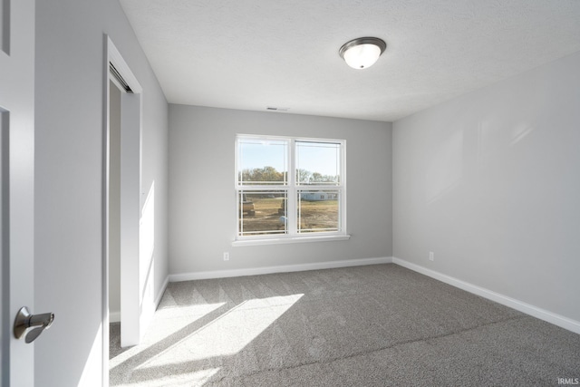 carpeted spare room featuring a textured ceiling