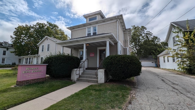 view of front facade with a front yard, a garage, and an outdoor structure