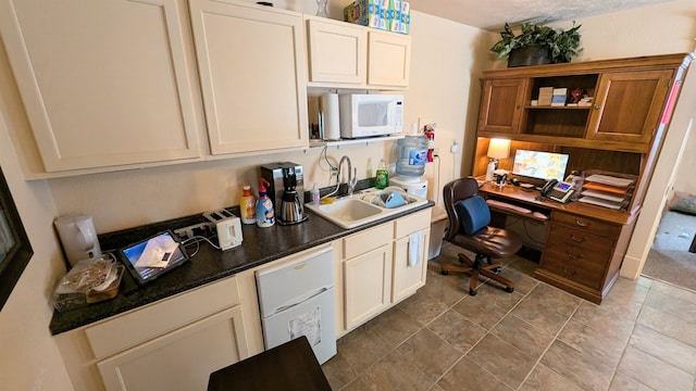 kitchen with built in desk, sink, and a textured ceiling