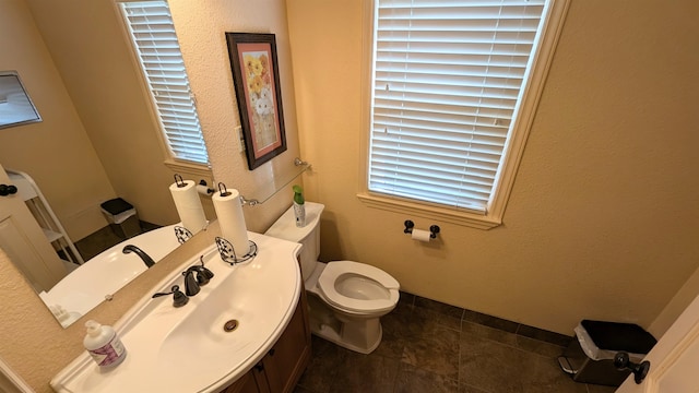 bathroom featuring toilet, a healthy amount of sunlight, vanity, and tile patterned flooring