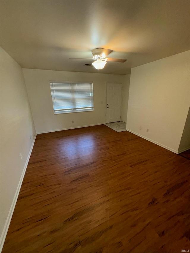 spare room featuring dark wood-type flooring and ceiling fan