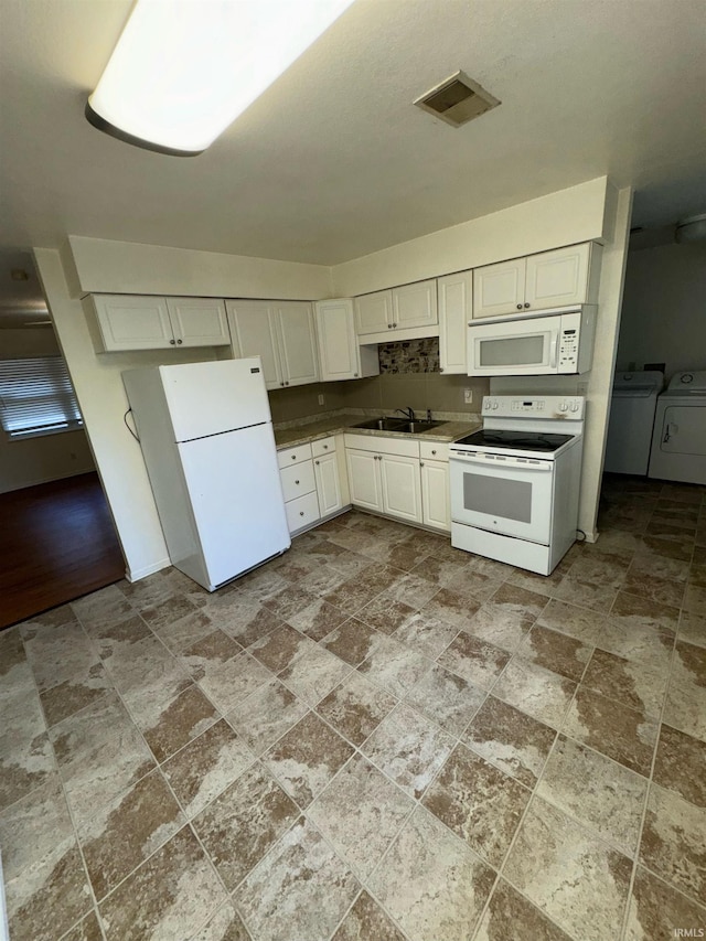 kitchen featuring white appliances, independent washer and dryer, sink, and white cabinets