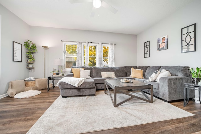 living room featuring dark wood-type flooring and ceiling fan