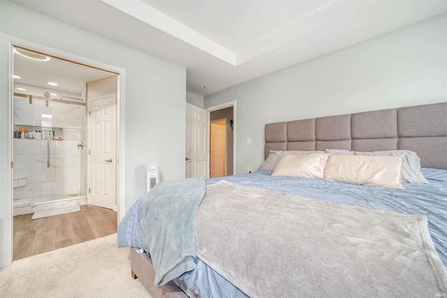 bedroom with ensuite bath and wood-type flooring