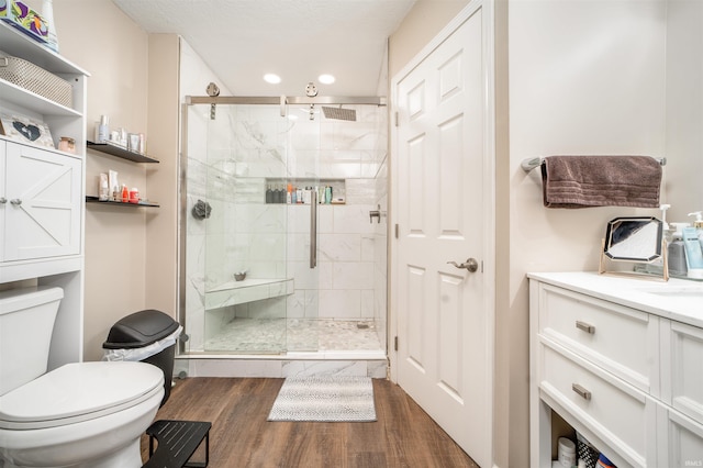 bathroom with a shower with door, toilet, hardwood / wood-style flooring, and vanity