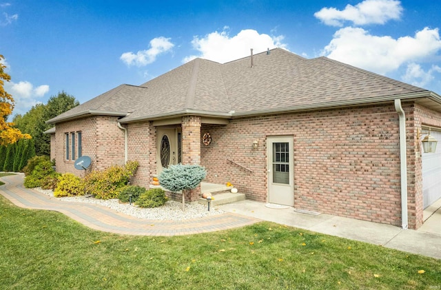 back of house with a lawn and a garage